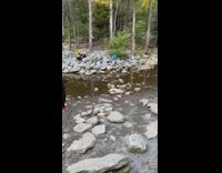 Guy black jacket stretch arms small waterfalls