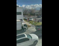 Woman with afro hair poses in front of a house