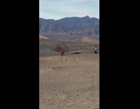 Guy throws handfuls of sand red sweater