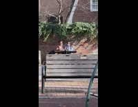 Couple on table film beside  brick wall