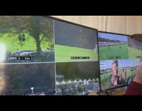 Camera screen, derby race horse trips over hedge hurdle and falls in grass with jockey