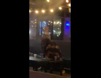 Old lady in black twerks over restaurant table 