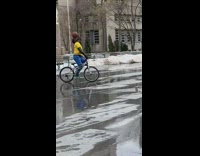 Guy on bicycle balances basketball on face 