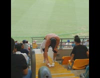 Guy chugs one of the beers hes holding at cricket game
