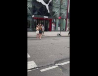 Two women in black and white dress poses on the side of the street