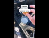 Guy inside car dips cookie in milk