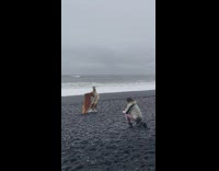 Woman in yellow outfit poses at the windy beach