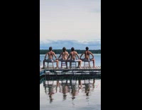 Four guys dance with chairs on dock 
