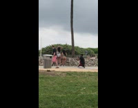 Two women twerk butt tattoo ledge beach