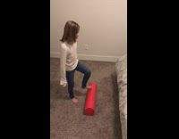 Girl does floss dance on red foam roller and falls down