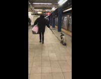 Man walks down with jacket and helmet on skateboard in subway station
