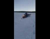 Guy on snowmobile accidentally falls over a small snow cliff