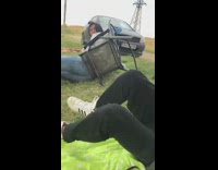 Guy kicks chair sleeping friend over grass