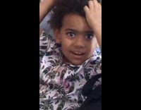 Little boy on couch plays with hair 