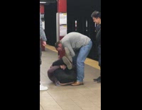 Friends laugh at guy laying in subway station 