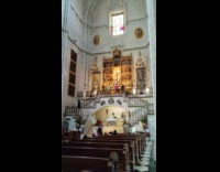 Woman in blue dress selfies with Mother Mary statue behind