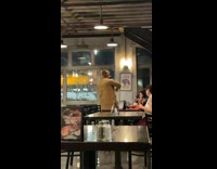 Man in brown winter coat tiktok dance inside the restaurant