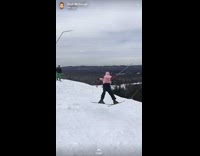 Guy jumps off ramp and spins sideways, falls down slope