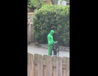 Guy covered in green lifts bike 