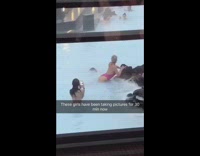 Woman sits on rocks in hot sauna pool and takes pictures