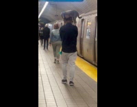 Man at subway station carries dog on shoulders