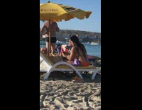 Woman Orange bikini selfie under yellow beach umbrella