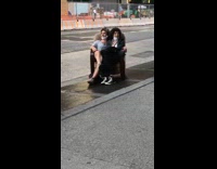 Couple sit in chair together vent sidewalk 