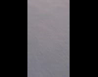 Man walks over frozen lake during sunset