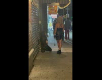 Man kneels next to woman holding whip