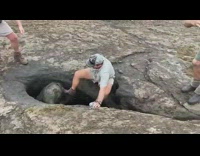 Men help baby elephant stuck in hole