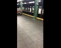 a man in army vest singing in subway station