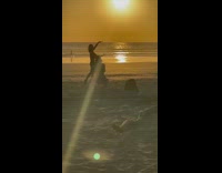 Woman hold top and bottom sunset beach