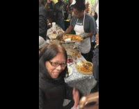 Woman serves food from Thanksgiving dinner to passengers on subway train
