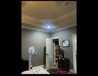 Little boy dunks basketball from dresser