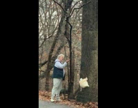 Old woman feeds park squirrels 