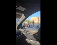 Woman films near the car of filmer