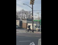 Man on Bike with Speakers Behind Crosses Street