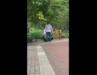 Guy at park wears white coat and cube robot mask 