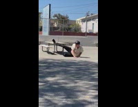 Skateboarder skates onto table but slips and falls