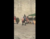 Shirtless guy waves black pirate flag around 