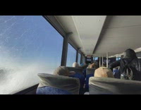 Waves crash on left side glass ship