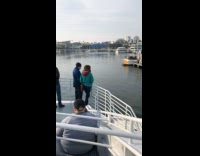 People stands on boat goes back port