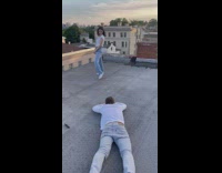 Guy lay on rooftop take pictures of girl