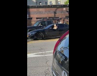 Dog sitting in the driver’s seat with half body outside window
