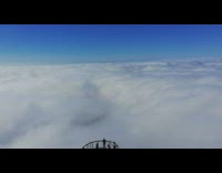 Guy above white clouds looks out window 
