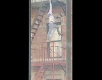 Guy standing on fire escape railing paints  