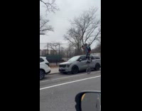 Man dance while riding unicycle on road