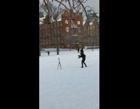 Woman black jacket blow snow hands tripod