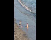 Woman in bikini kneels with hands behind her head
