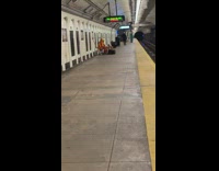 Orange shirt plays drums in subway station